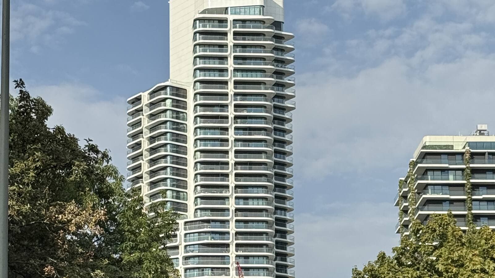Grand Tower at Europa-Allee 2 seen from street level, showing the hexagonal balcony modules of the honeycomb façade