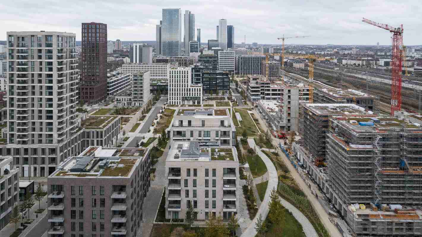 Aerial view of Frankfurt's Europaviertel mid-construction, residential blocks in the foreground and the banking district skyline behind