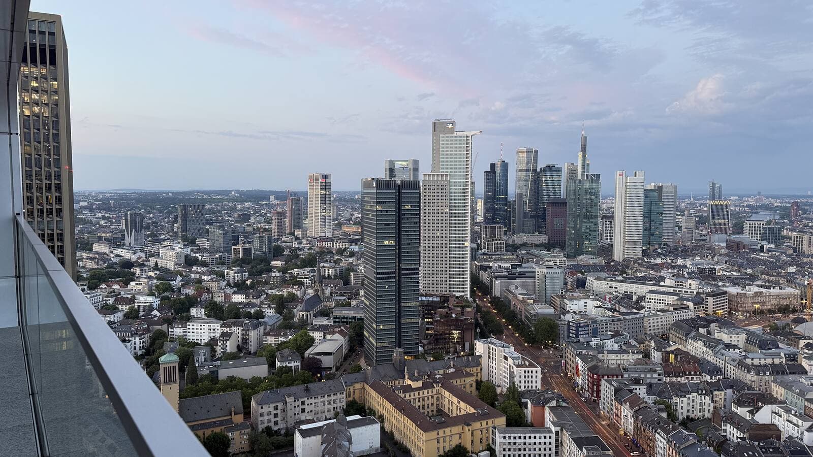 The Europaviertel and the Frankfurt skyline at dusk, seen from a high floor of Grand Tower